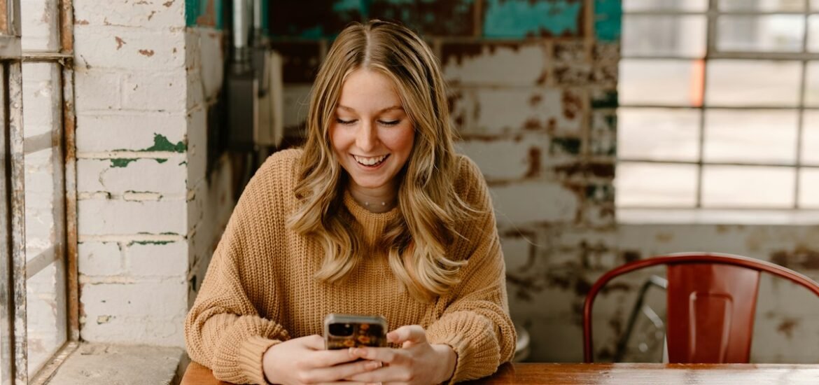 How to earn money using your phone: a woman looking at her phone at a table