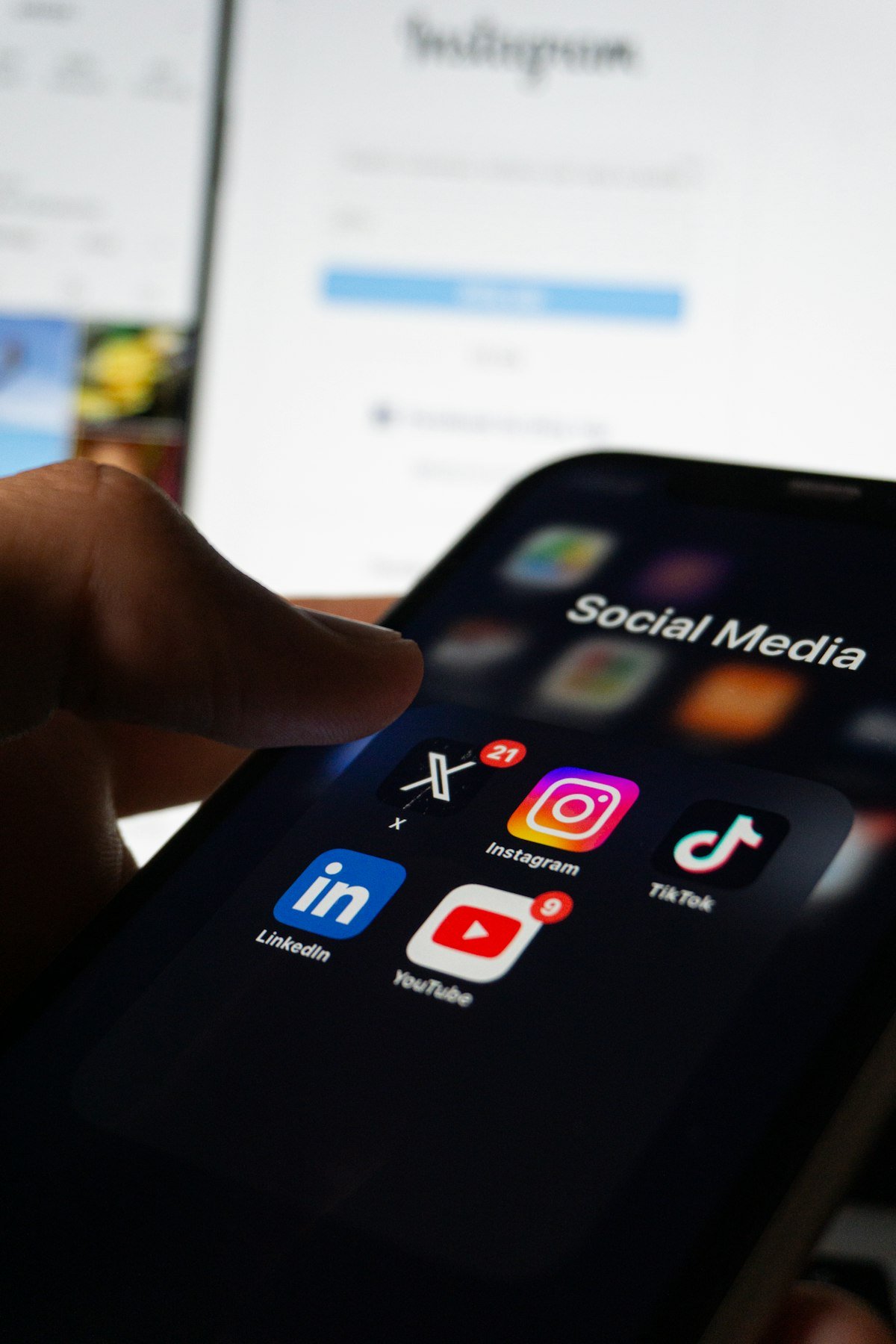 A person holding a phone with social media apps on screen