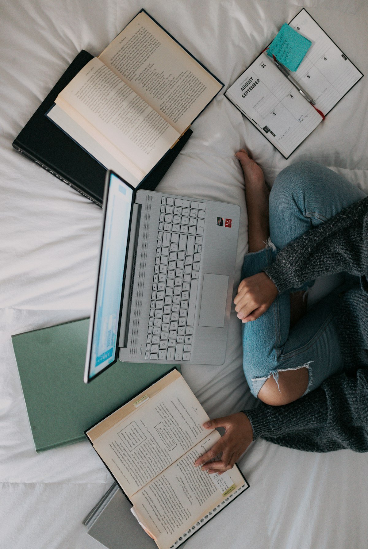 A person studying with a laptop and books