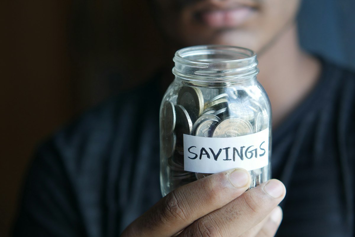 A man holding a savings jar