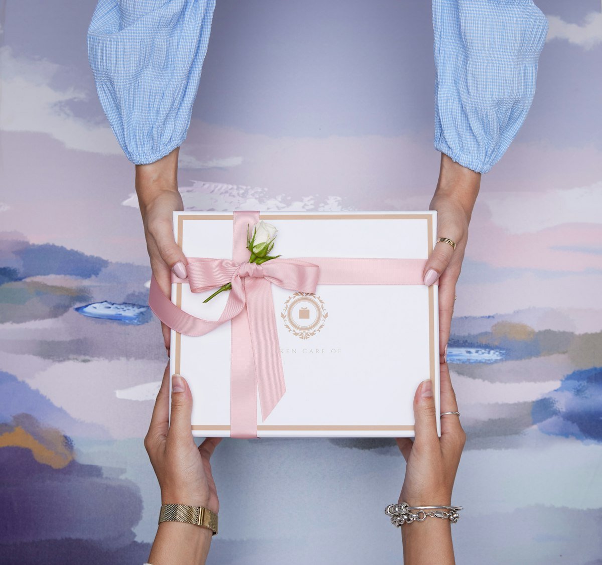 Two hands exchanging a wrapped gift
